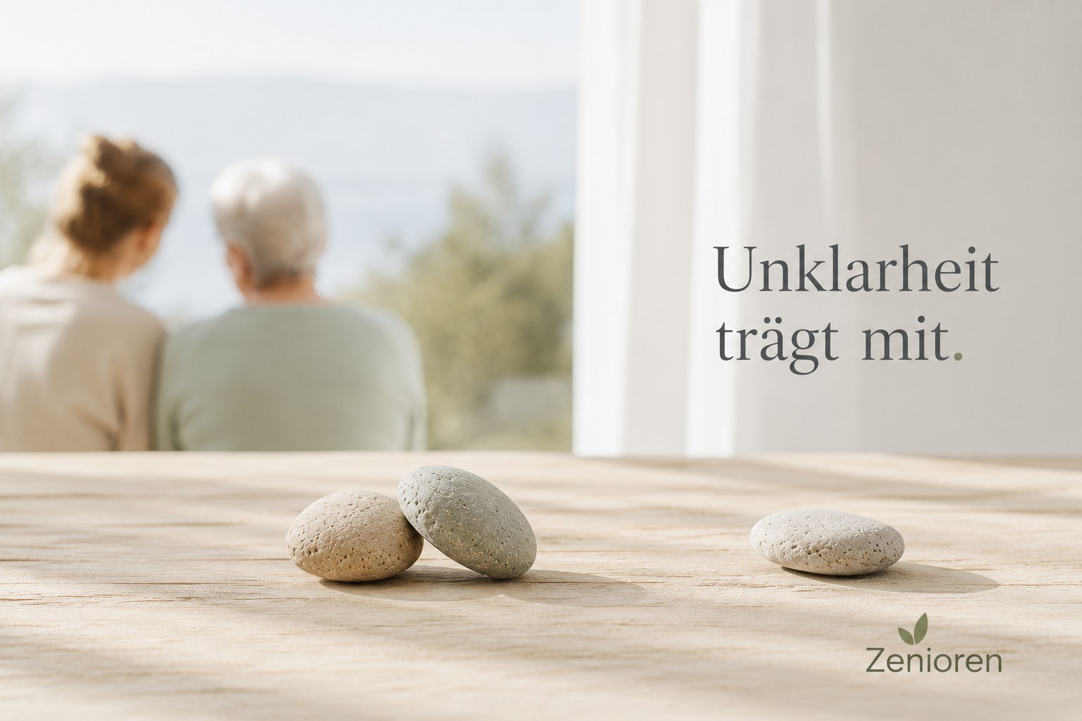 Ruhiges Zenioren-Markenbild mit zwei naturbelassenen Steinen in Beziehung und einem einzelnen Stein in leichtem Abstand auf einer hellen Holzfläche. Im Hintergrund sitzen zwei Menschen unscharf nebeneinander im klaren Tageslicht. Der Overlaytext „Unklarheit trägt mit.“ vermittelt Generationenbeziehung, unausgesprochene Themen und mögliche Entlastung.